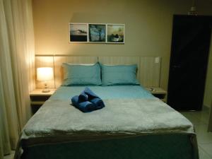 a bedroom with a large bed with blue pillows at Pousada Marlin Azul in Fernando de Noronha