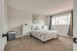 a white bedroom with a bed and a window at Cozy home! 16 Min away from strip and fremont in Las Vegas