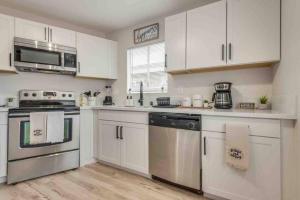 a kitchen with white cabinets and stainless steel appliances at Cozy home! 16 Min away from strip and fremont in Las Vegas