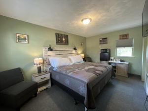 a bedroom with a bed and a chair in it at Cedars Motel in Saint Ignace