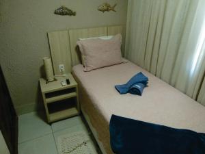 a small bedroom with two beds and a night stand at Pousada Marlin Azul in Fernando de Noronha