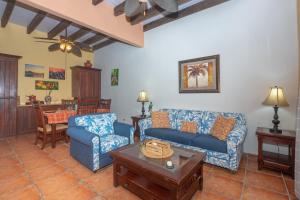 a living room with blue couches and a table at Caribbean Breeze 6A Condo in Roatán