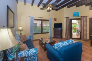 a living room with blue couches and a tv at Caribbean Breeze 6A Condo in Roatán