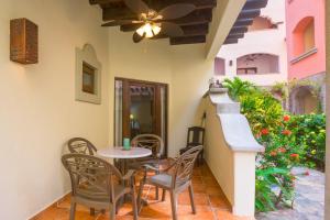 a patio with a table and chairs and a ceiling fan at Caribbean Breeze 6A Condo in Roatán