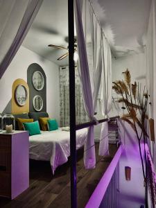 a bedroom with a bed with purple and green pillows at La Casica del Abuelo Valentín 