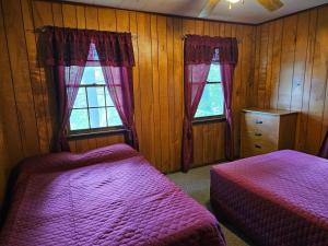 1 dormitorio con 2 camas y 2 ventanas en The Gold Eagle, en Lake George