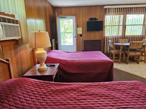 a hotel room with two beds and a table and a television at The Gold Eagle in Lake George