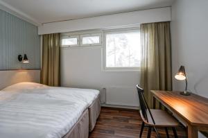 1 dormitorio con cama, escritorio, cama y ventana en Forenom Serviced Apartments Espoo Tapiola, en Espoo
