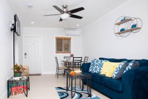 a living room with a blue couch and a ceiling fan at Sheer Bliss BeachView Apt #1 in Georgetown