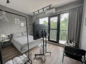 a bedroom with a bed and a television and a chair at hsueh_house in Yilan City