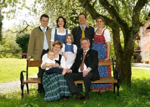 una familia posando para una foto en un banco en Hotel Johannisbad en Bad Aibling