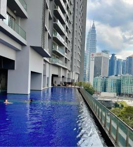 a swimming pool in the middle of a city with buildings at MyHabitat - KLCC 2 bedroom in Kuala Lumpur