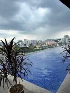 a large swimming pool with a view of a city at MyHabitat - KLCC 2 bedroom in Kuala Lumpur