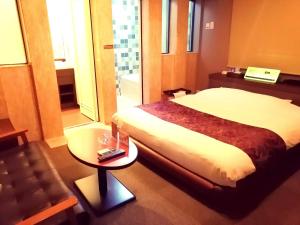 um quarto de hotel com uma cama e uma mesa em HOTEL WILL渋谷 LOVE HOTEL -Adult only- em Tóquio