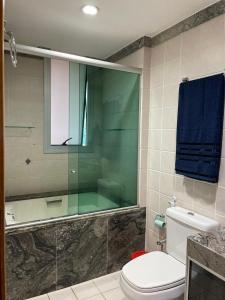 uma casa de banho com um WC e uma cabina de duche em vidro. em Promoção - Flat em Brasília em Brasília
