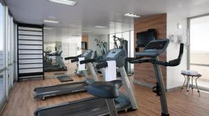 a gym with several tread machines in a room at Promoção - Flat em Brasília in Brasília