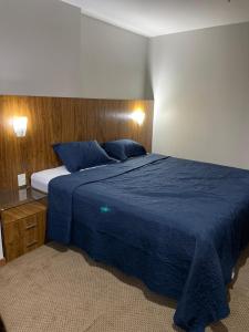 um quarto com uma cama azul e um cobertor azul em Promoção - Flat em Brasília em Brasília