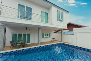 een villa met een zwembad en een huis bij Relax Pool Villa Near Walking Street,jacuzzi ,BBQ 5Bed 6Bath City house54 in Pattaya South