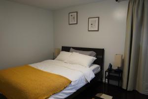 Un dormitorio con una cama con una manta amarilla. en Patio privé, hébergement équipé et spacieux. en Hamilton