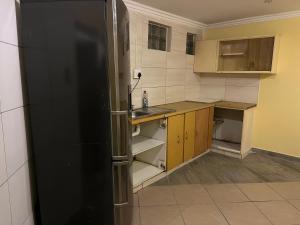a kitchen with a black refrigerator and wooden cabinets at Eldos Guest House in Soweto