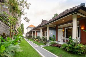 a row of cottages with grass and plants at Utama Villas Beach Front Candidasa in Candidasa
