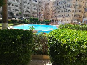 a swimming pool in front of a large building at Chalet At Wahet Al Nakhil resort in Alexandria