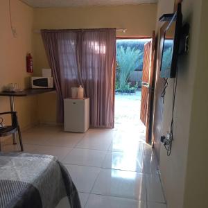 a room with a bed and a television and a door at camila guest house in Rundu