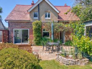 a house with a patio and a table and chairs at Framingham in South Hayling