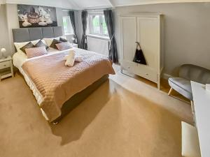 a bedroom with a bed with a stuffed animal on it at The West Wing - 26666 in Corbridge
