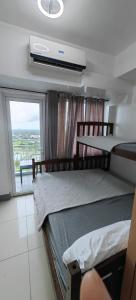 um quarto com 2 beliches e uma janela em Wind Residences by JG Vacation Rentals em Tagaytay