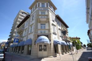 a large building on a street with a parking meter at Hotel Villa Bernt in Grado