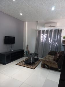 a living room with a bed and a tv at camila guest house in Rundu