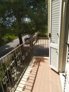 eine offene Tür zu einer Veranda mit einem Zaun in der Unterkunft Casa Forola Holiday House in Acquaviva Picena