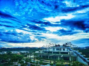 ein Gebäude mit wolkigem Himmel im Hintergrund in der Unterkunft MONIC STAYCATION #Green Haven near Senibong&Regency in Masai