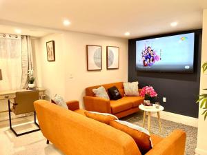 a living room with two couches and a flat screen tv at Roslindale village condos in Boston