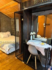 a bedroom with a bed and a desk in a room at บ้านพักกึ๊ดเติง แม่กำปอง เชียงใหม่ in Mae On