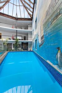 a large swimming pool in a building with a glass ceiling at The Surrey Hotel in Auckland