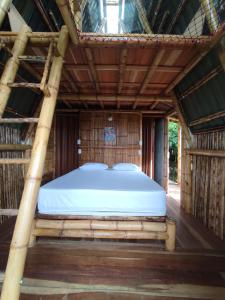 uma cama num quarto com telhado de madeira em El Turpial em Jericó