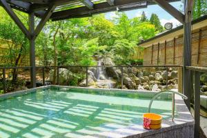 a swimming pool with a waterfall in a garden at TAOYA Akiu in Sendai