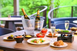 a table with two bottles of champagne and plates of food at TAOYA Akiu in Sendai +18 photos
