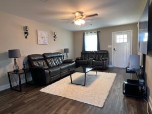a living room with leather furniture and a ceiling fan at Spotless in Clarksville