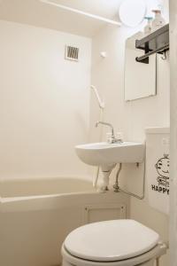 a bathroom with a white toilet and a sink at 桜の宿 in Osaka