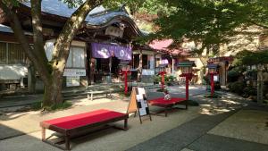 un parc avec bancs devant un bâtiment dans l'établissement Dainichiya-ryokan, à Sasaguri