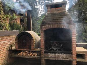 un horno de ladrillo al aire libre con humo saliendo en La casa de los volcanes / Volcano House, 