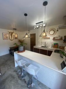 a kitchen with a white counter and two stools at Entire Villa near Surigao City in Surigao +6 photos