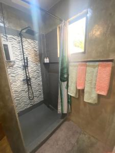 a bathroom with a shower with orange and white towels at Entire Villa near Surigao City in Surigao