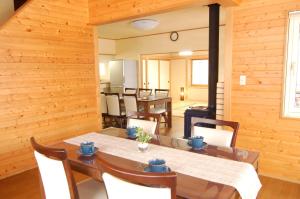 uma sala de jantar com paredes de madeira e uma mesa e cadeiras em Shakunagedaira Rental cottage - Vacation STAY 18462v em Numanokura