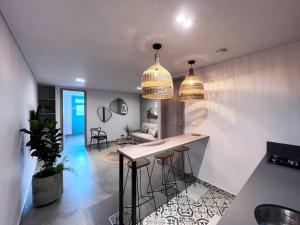 a kitchen with two pendant lights and a bar with stools at Parallelo Loft Salento P3 in Salento