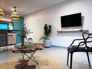 uma sala de estar com uma mesa e uma televisão em Parallelo Loft Salento P3 em Salento