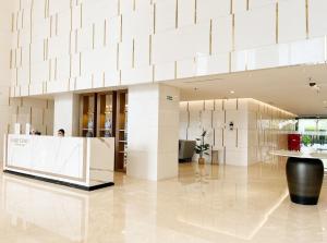 een lobby van een gebouw met een grote witte muur bij Gold Coast Sea View Apartments by Rentrooms in Jakarta